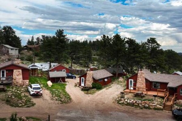 Un ensemble de chalets aux façades en pierre et en bois, niché au cœur d’un paysage boisé.
