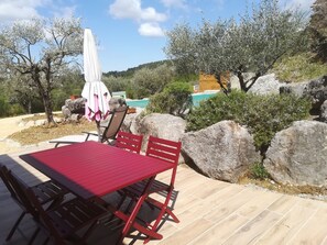Relax in a tranquil outdoor setting with a pool and lush greenery.