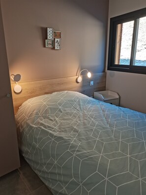 Restful retreat with a neatly made bed and a geometric-patterned duvet.