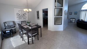 Un espacio de estar moderno con comedor, cocina y una escalera.