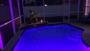 Una piscina de borde curvo y una pequeña isla con una estatua.
