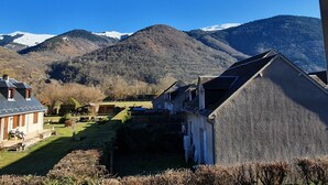 Ein Wohngebiet mit Häusern, einem kleinen Garten und Blick auf schneebedeckte Berge.