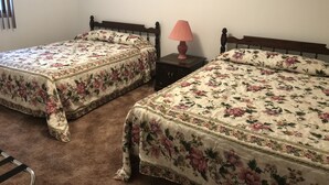 Two single beds with floral bedding, a wooden headboard, a nightstand with a lamp, and a window with blinds. - 9 - Clean, Comfortable and Quiet Condo at the base of Jackson Creek Summit (Wakefield)