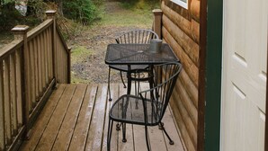 A wooden cabin with a deck, a table, and chairs. - Private Cabin with Open Loft - Sleeps 3-6 (Seward)