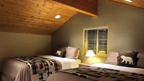 A cozy bedroom with two beds, a window with blinds, and a wooden ceiling. - Private Cabin with Open Loft - Sleeps 3-6 (Seward)