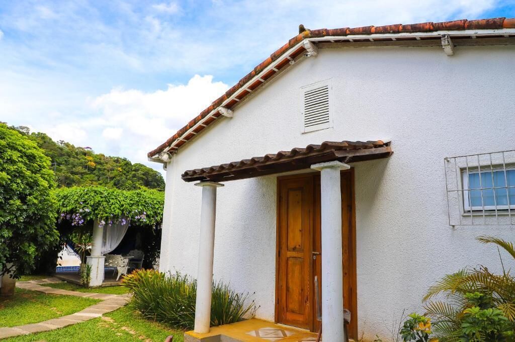 A white building with a tiled roof, a wooden door, and a small window.