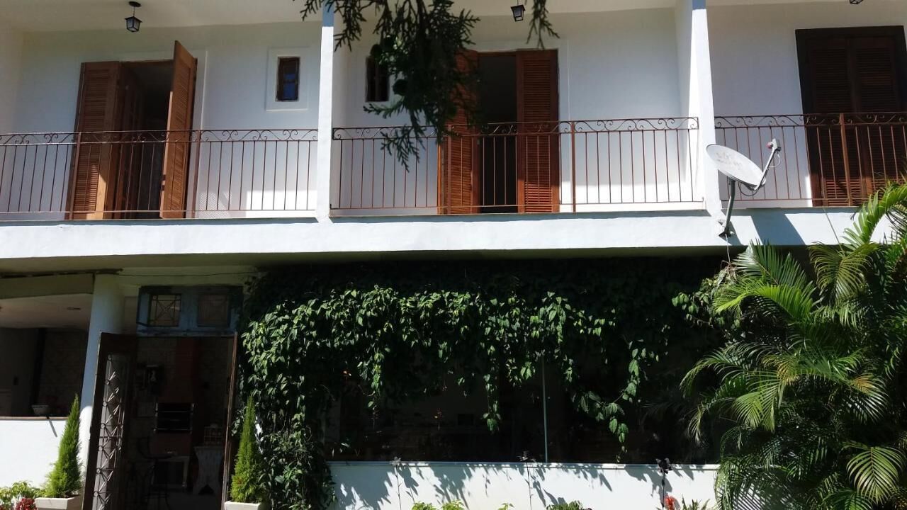 Un immeuble de deux étages doté d’un balcon, d’une antenne parabolique et d’une porte ornée d’un motif géométrique.