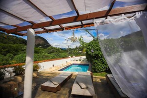 Una piscina al aire libre, sillones reclinables de piscina