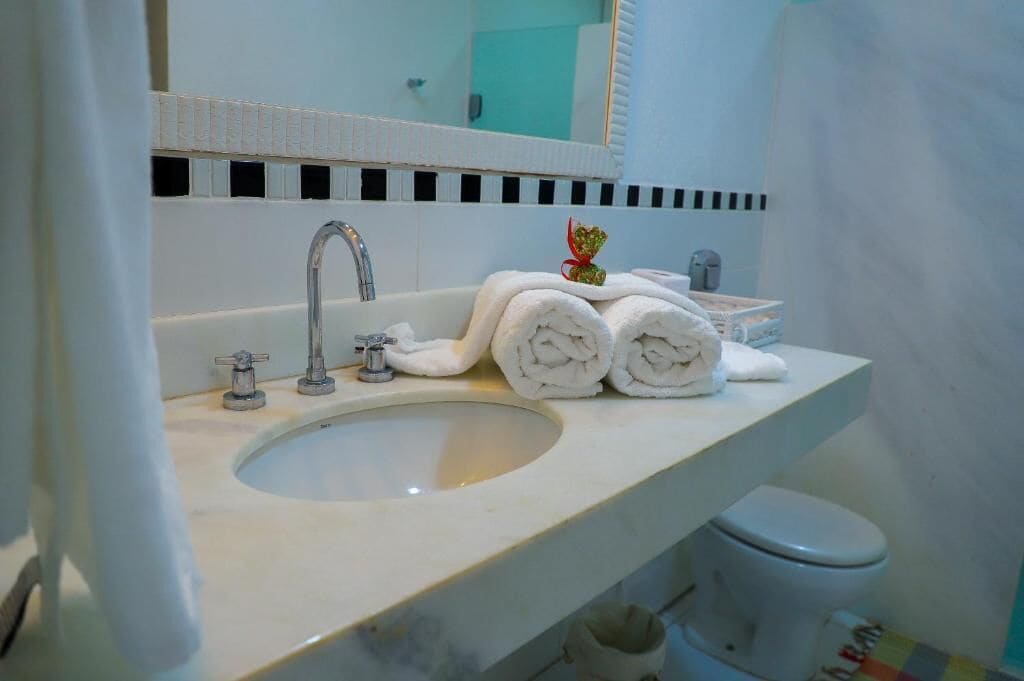 A bathroom with a sink, mirror, and toilet.
