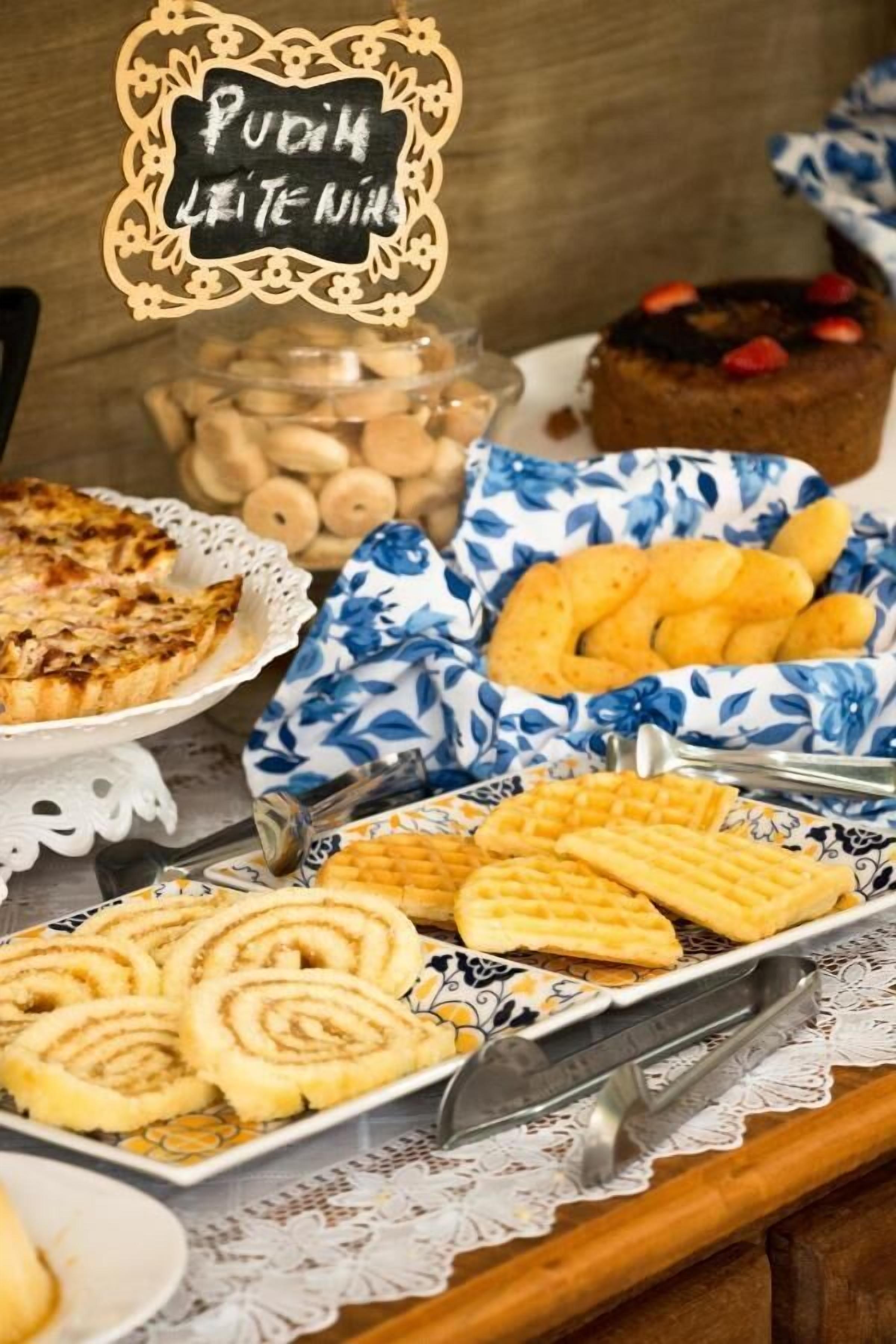 Une table de buffet proposant divers desserts, notamment une tarte, un gâteau et des pâtisseries enroulées.
