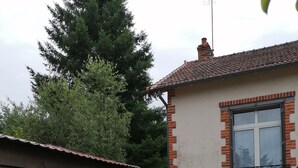 Eine Terrasse mit Grill, zwei Liegestühlen und einer Steinmauer.
