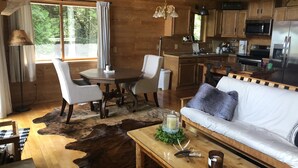 A cozy cabin interior with a dining area, sofa, and kitchen. - Pure Michigan on Lake Michigan-Manistique, miles of sandy beach fun (Manistique)