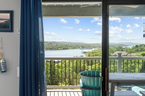 Ein Balkon mit Seeblick, umgeben von Grünflächen und Häusern.