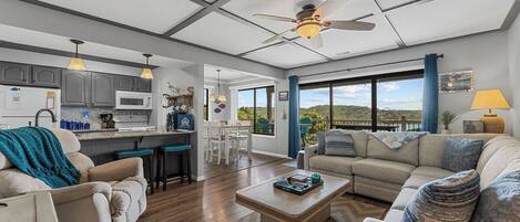 A modern living room with a sofa, coffee table, and a view of the outdoors.