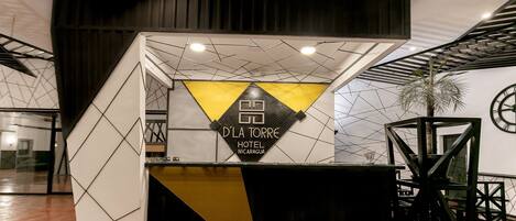 Mostrador de recepción con diseño geométrico y letrero del Hotel D'La Torre en Nicaragua.
