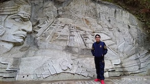 A stone carving with a face and geometric patterns. - Andino Machupicchu (Machu Picchu)