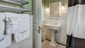 A bathroom with a white sink, a mirror, and a towel rack with towels. - Charming Carriage House, Heated Pool Access (Savannah)