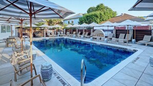 A pool area with lounge chairs, umbrellas, and a sign indicating no diving. - Charming Carriage House, Heated Pool Access (Savannah)