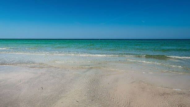 A beach with clear turquoise water and a sandy shore. - Intercoastal waterfront home with Beautiful Bayside pool (Indian Rocks Beach)