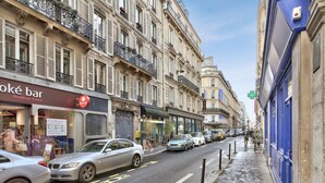 A street lined with historic buildings, a café, and parked cars. - Appartement Ricca - Welkeys (Paris)