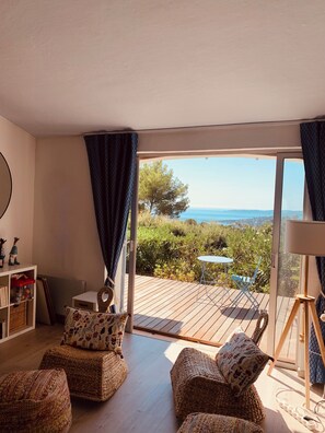 Una habitación acogedora con muebles de mimbre, una mesita y vistas al exterior.