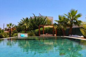 A clear swimming pool with a wooden pergola and lounge chairs, surrounded by palm trees and greenery. - Beautiful Algarve Pool Villa Bali with a private garden - 15min to beach (Portimao)