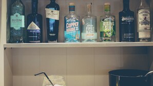 A kitchen counter with a variety of liquor bottles and a cocktail glass. - Test property Compliance 1 (Kula)
