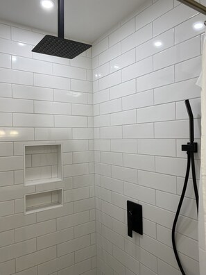 Chuveiro, secador de cabelo, toalhas de banho, papel higiênico
