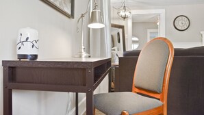 A modern living room with a dark wooden table, a white lamp, and a grey upholstered chair. - Ivywild Bungalow ↠Close to Trails/Downtown/Shops↞ (Colorado Springs)