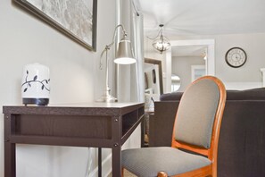 A modern living room with a dark wooden table, a white lamp, and a grey upholstered chair. - Ivywild Bungalow ↠Close to Trails/Downtown/Shops↞ (Colorado Springs)