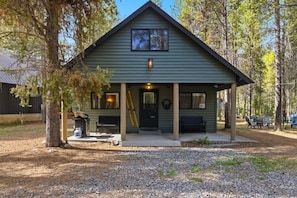 Un lodge con un portico, una porta d'ingresso e una piccola finestra sopra la porta.