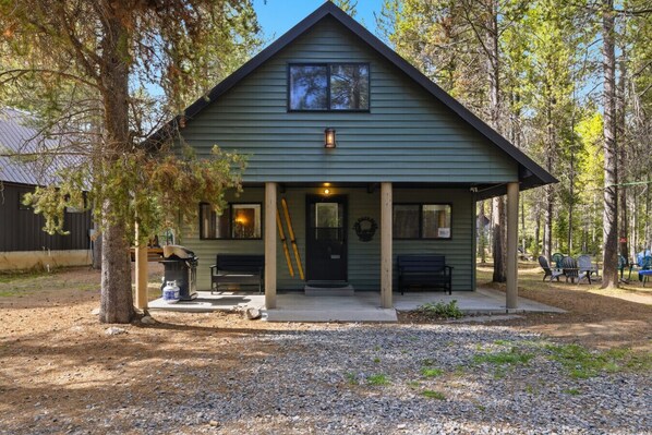 A lodge with a porch, a front door, and a small outdoor seating area.