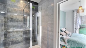 Un baño moderno con cabina de ducha de vidrio y un inodoro a la vista.