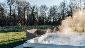 Un jacuzzi rodeado de césped y árboles.
