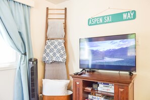 Une chambre avec un lit, une télévision, un radiateur et une pancarte indiquant « Aspen Ski Way ».