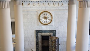 A grand entrance with a large clock and columns, leading to a dark interior. - The Liberty Trust (Roanoke)
