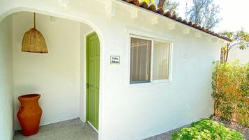 Un edificio blanco con una puerta verde, una ventana y un letrero que dice "Villa Mikonos".