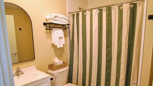 A bathroom with a toilet, sink, and a shower curtain.