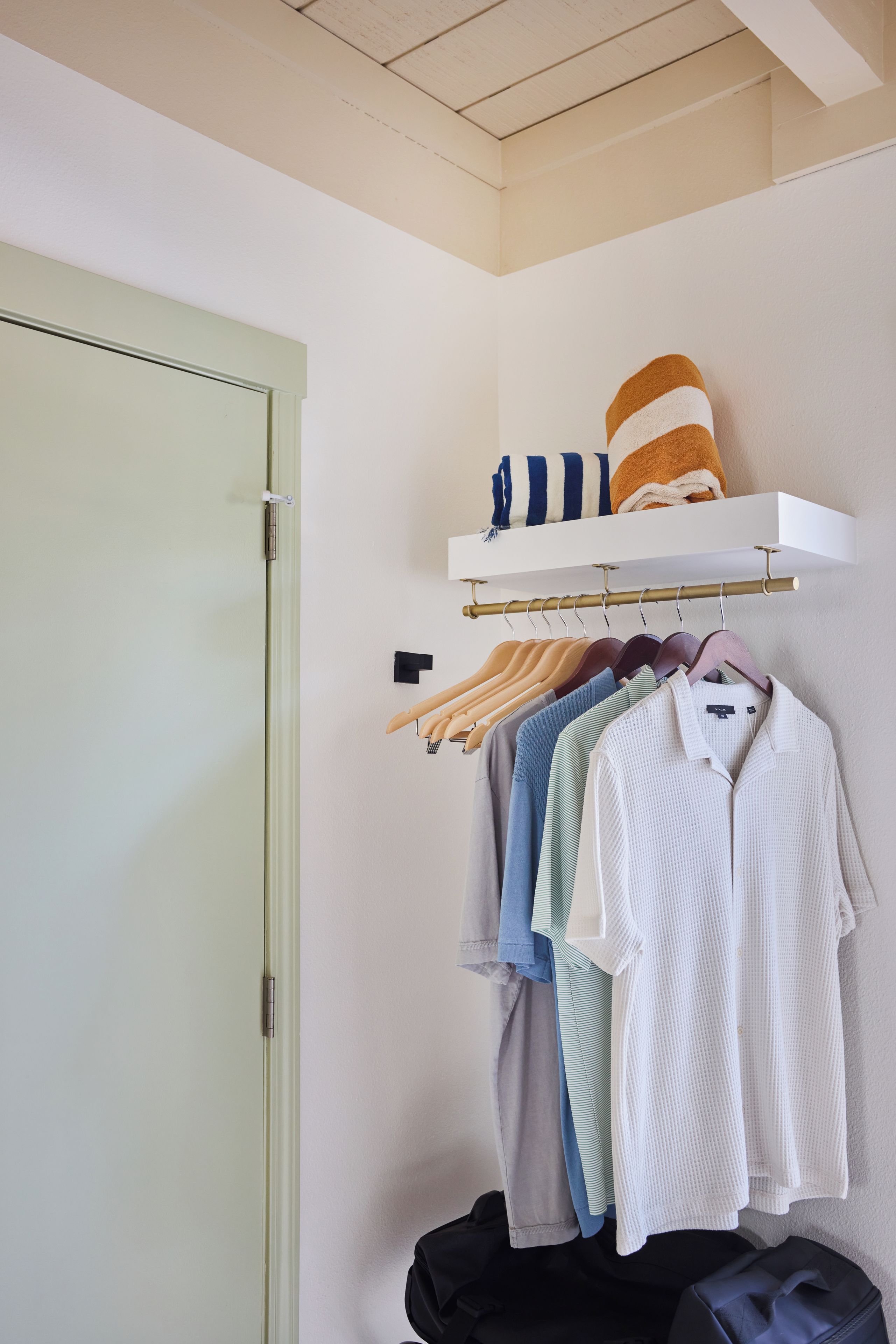 Ein Schrank mit Kleiderstange und Ablagefläche f ür gefaltete Wäsche.