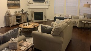 A living room with a fireplace, sofa, and television. - Welcome to Casa Seabrook, your By-The-Sea-Get-Away!! (Seabrook)