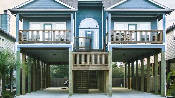 A two-story house with a covered front porch and a central staircase. - Welcome to Casa Seabrook, your By-The-Sea-Get-Away!! (Seabrook)