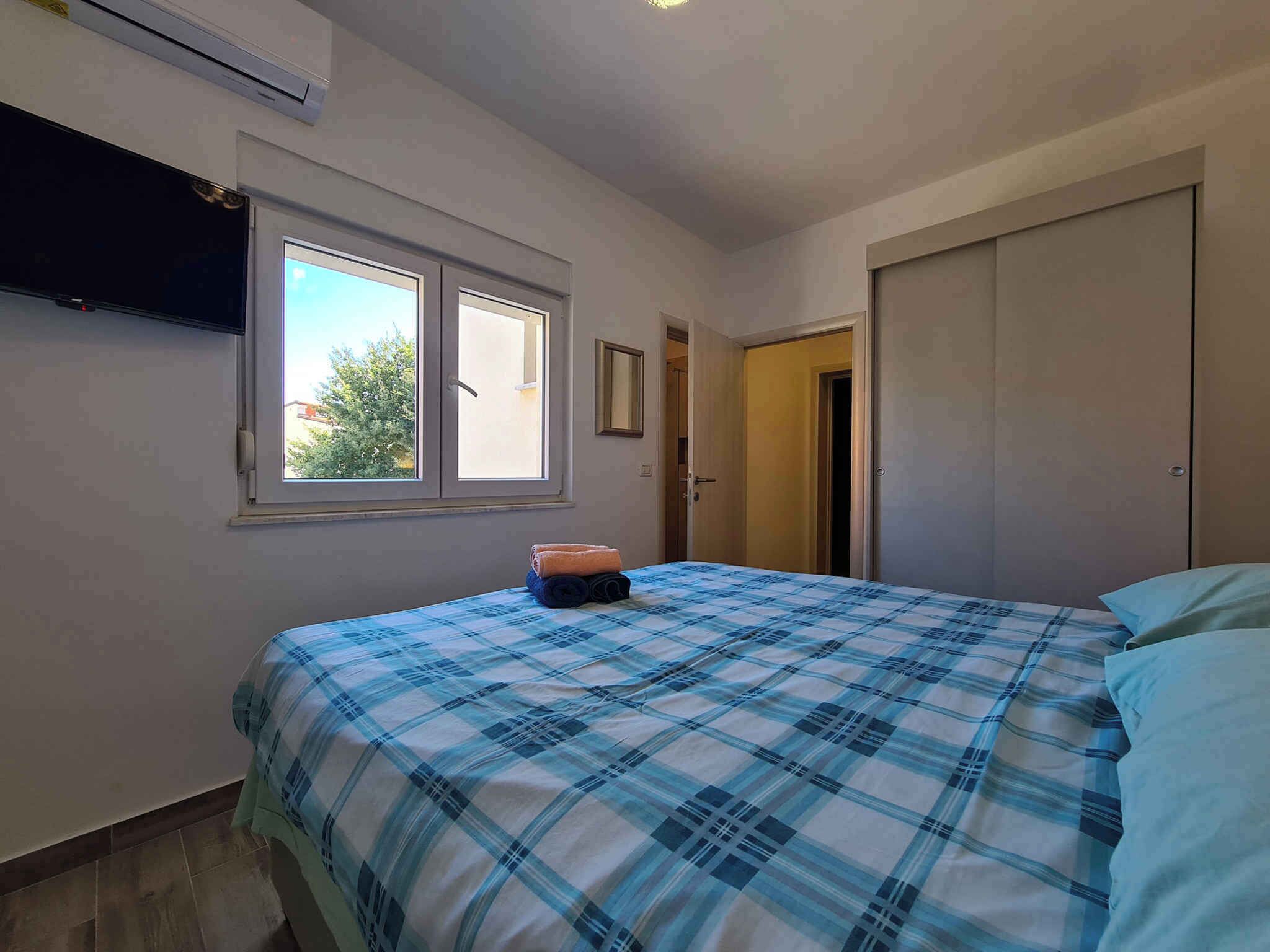 Ein Schlafzimmer mit Bett, Fenster und Kleiderschrank.