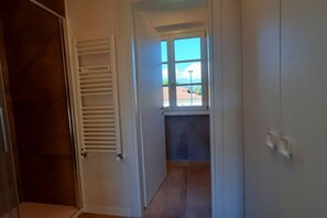 Ein Flur mit Fenster, Tür und Heizkörper.