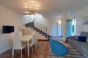 Ein modernes Wohnzimmer mit Treppe, Essbereich und Sofa.