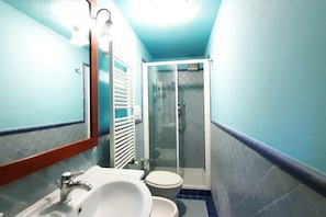 Ein Badezimmer mit Waschbecken, Toilette und einer Duschkabine.