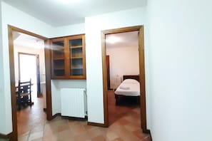A room with a radiator, a bed, and a wooden cabinet.