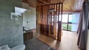Une salle de bain moderne avec un plafond en bois, une cloison en verre, un lavabo et des toilettes.