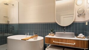 A modern bathroom with a freestanding bathtub, a vanity with a sink, and a mirror. - Ecole St Pierre Hotel (Istanbul)