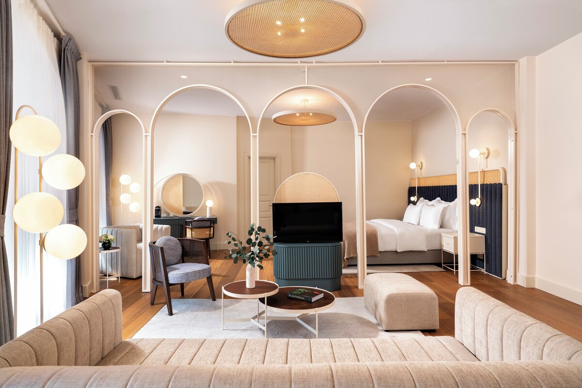 Une chambre d’hôtel moderne comprenant un espace de vie, un coin repas et une chambre à coucher.