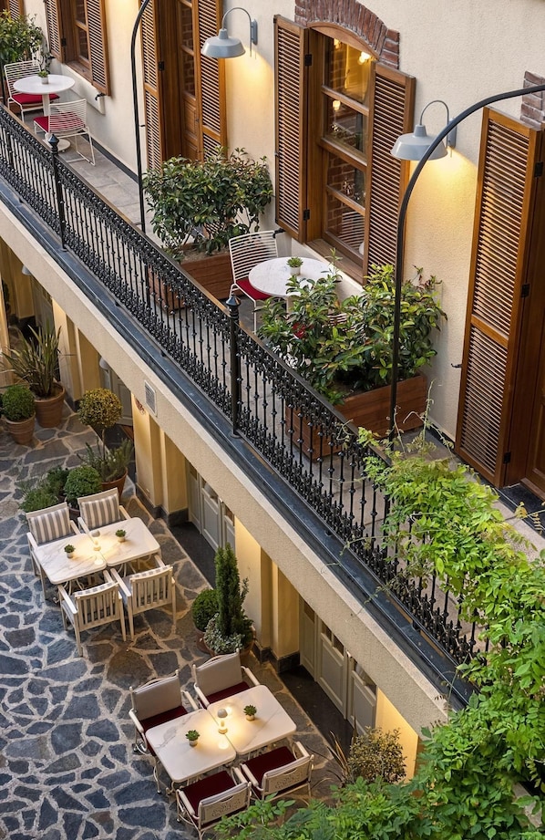 A multi-level outdoor terrace with stone flooring, multiple seating areas, and potted plants. - Ecole St Pierre Hotel (Istanbul)